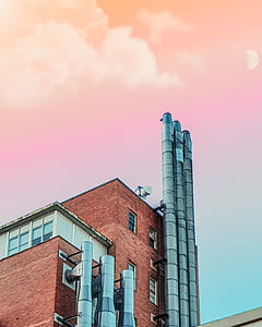 worm's eye view of building with exhaust under pink sky thumbnail