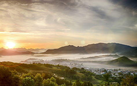 aerial photo of fog-covered village in valley during sunrise thumbnail