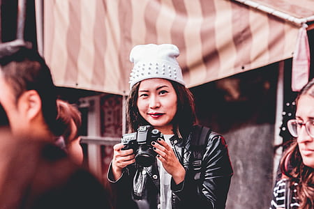 woman holding black DSLR camera during daytime thumbnail