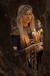 woman holding yellow taper candles thumbnail