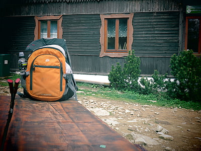 orange and black backpack on table thumbnail