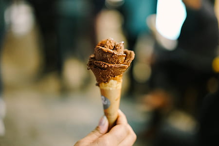 person holding scoops of ice cream on cone thumbnail