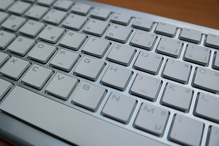 grey and white computer keyboard on brown surface thumbnail