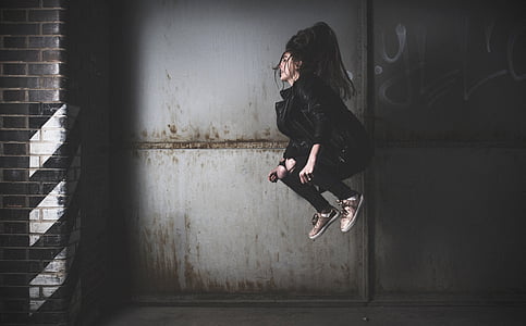 woman in black leather jacket performing jump photography thumbnail