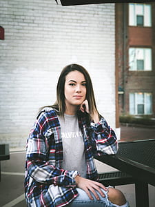 selective focus photography of woman sitting on picnic table thumbnail