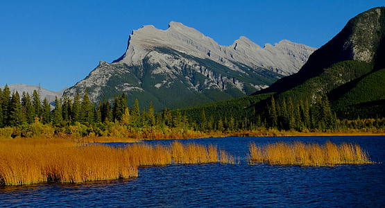 body of water near mountain during daytime thumbnail