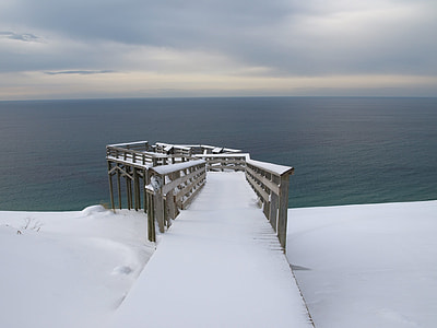 snow-capped brown wooden dock near sea at daytime thumbnail