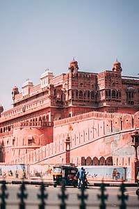 Auto Rickshaw Parked Beside Brown Structure thumbnail