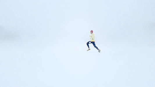 person in yellow sweatshirt and black pants running in white room thumbnail