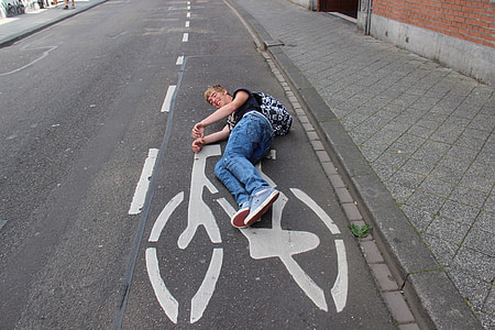 man laying on concrete road thumbnail