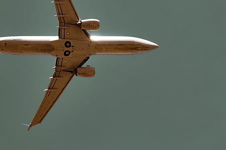 low-angle photograph of white airplane flying on sky thumbnail