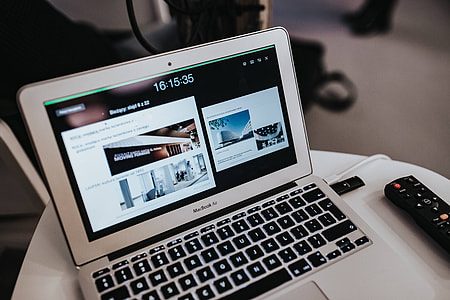White laptop on a table with a remote thumbnail