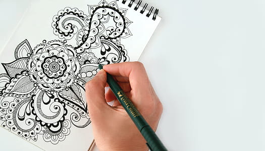 Person Holding Black Pen Sketching Flower thumbnail