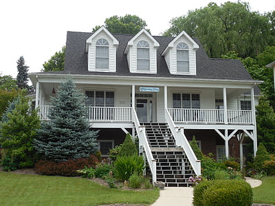 view of wooden house surrounded by trees and plants thumbnail