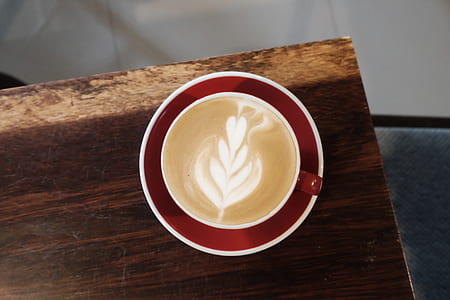 white and red ceramic mug filled with brown coffee thumbnail