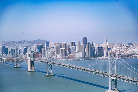 gray suspension bridge near high-rise buildings thumbnail