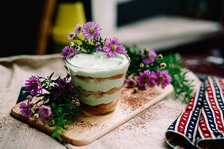 purple petaled flowers beside clear drinking glass thumbnail