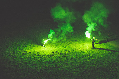 People holding green flares at night thumbnail