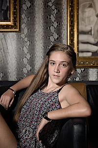 woman sitting on black chair looking at camera thumbnail