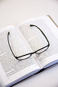 black framed eyeglasses on top of an opened book on white surface thumbnail