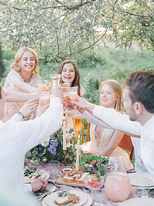 people holding footed glasses in front of dining table thumbnail