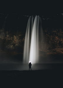 person standing near waterfalls thumbnail