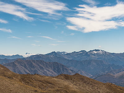 high-angle photography of mountain ranges under white clouded blue sky during daytime thumbnail