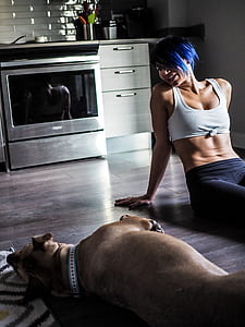woman sitting on floor beside of brown dog in the room thumbnail