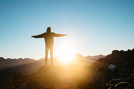man standing on brown rock thumbnail