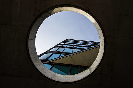 worm's-eye view photography of blue glass-panel building on hole thumbnail