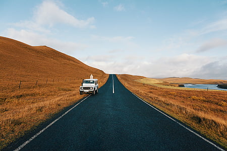 white SUV parked on brown grass field near road during daytime thumbnail