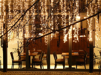 empty tables and chairs with string lights thumbnail