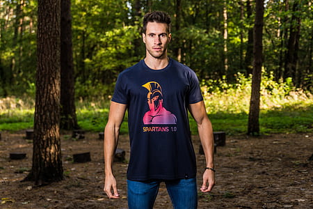 man in gray crew-neck shirt with both hands on side standing near trees thumbnail