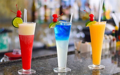 three clear beverage glasses with filled with beverage thumbnail