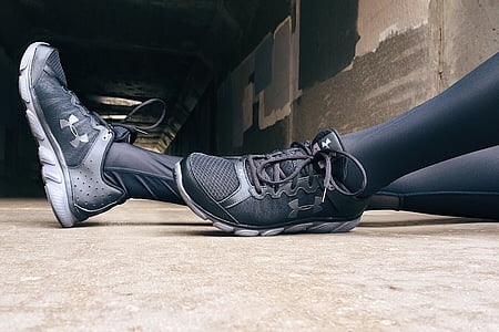person wearing pair of black Under Armour running shoes thumbnail