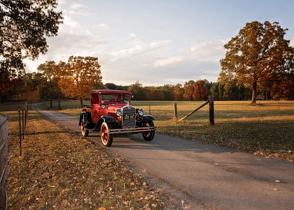 classic red vehicle near tree thumbnail