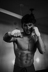 grayscale photo of a man boxing in a room thumbnail