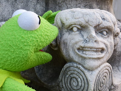green frog beside concrete statue at daytime thumbnail