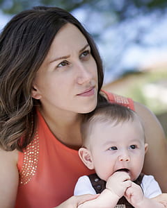 woman in orange shirt carrying toddler in white shirt thumbnail