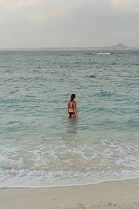 woman in bikini near shoreline thumbnail