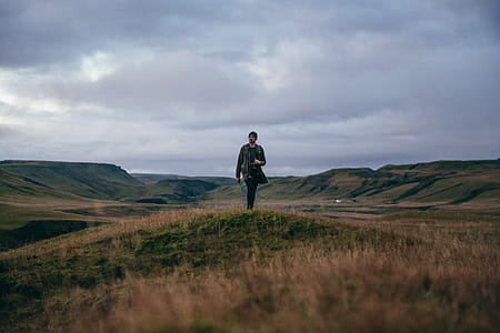 A hiker carrying a camera in rocky Iceland field thumbnail