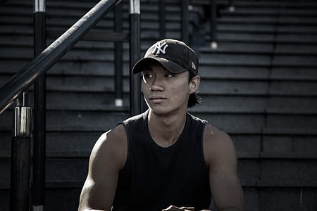 Man in Black Tank Top Sitting on Staircase thumbnail