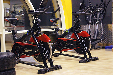 two red-and-black stationary bikes near tires thumbnail