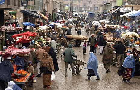 people wearing capes walking on street near market thumbnail
