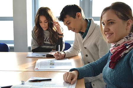 two women and one man sitting on chair and looking at a book thumbnail