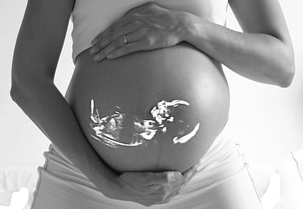 grayscale photo of woman holding her belly with baby thumbnail