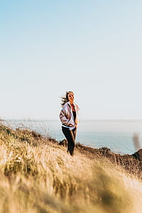 woman standing grass near bodies of water thumbnail