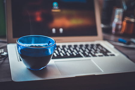 Blue Glass Cup on Silver Laptop Computer thumbnail