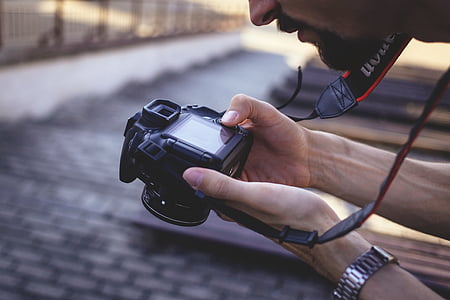 person holding black Canon DSLR camera thumbnail