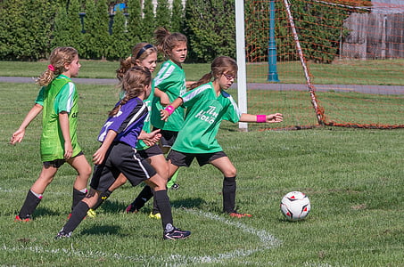 girls playing soccer during daytime thumbnail